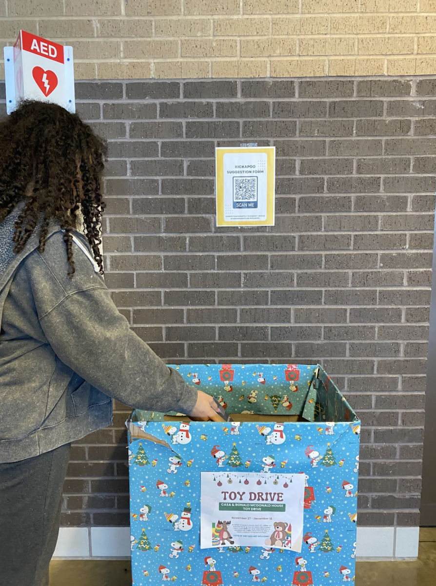 Student adds to the box of toys wanting to help other kids enjoy a joyful holiday season.